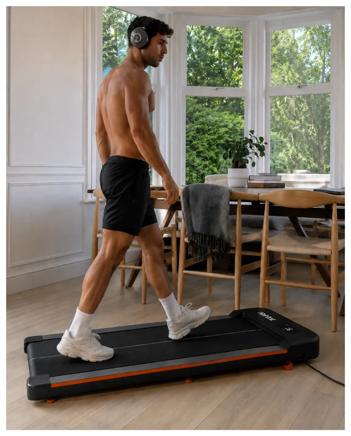 Marko geht in seiner Münchner Wohnung auf dem STRYDE Walking Pad — Hoodie, Shorts, Apple Watch